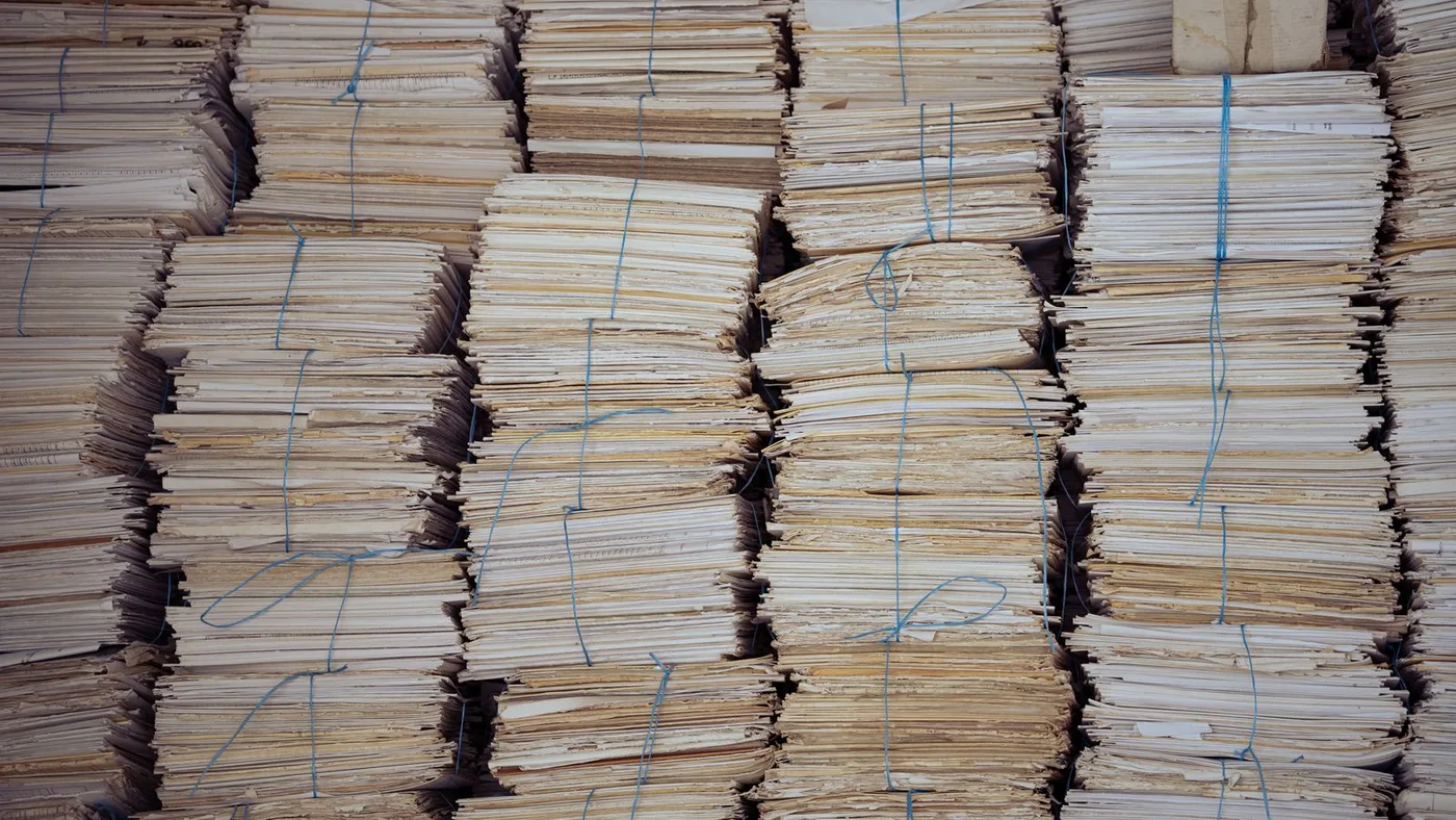 Towering stacks of paper files tied with string