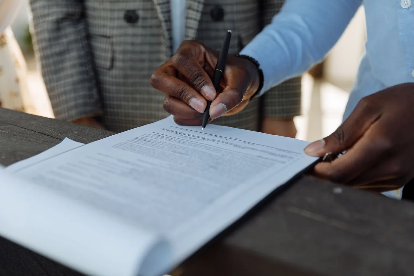 Two people signing a document at a desk