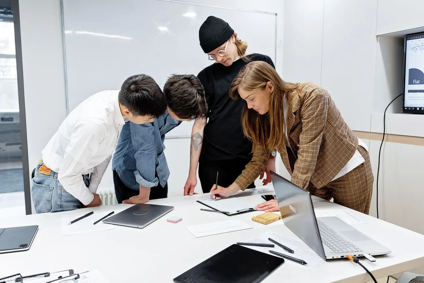 Team standing around a table working through documents together