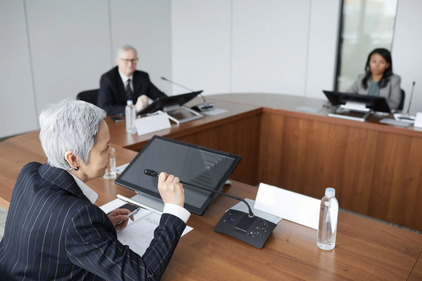 Three senior executives in discussion around a boardroom table